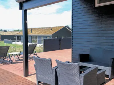 a patio with chairs and a table on a deck at 8 person holiday home in Saltum-By Traum in Saltum