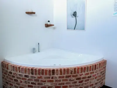 a bathroom with a bath tub made out of a brick wall at 8 person holiday home in Saltum-By Traum in Saltum