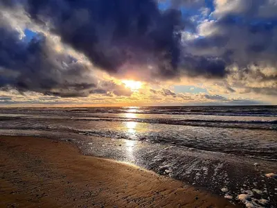 a sunset on a beach with the ocean at 10 person holiday home in Løkken-By Traum in Løkken