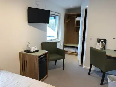 a hotel room with a bed and a desk and chairs at Rold StorKro in Skorping
