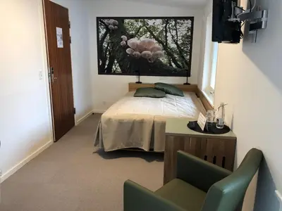 a bedroom with a bed with a large window at Rold StorKro in Skorping