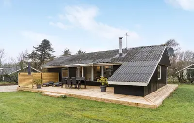 a small black house with a wooden deck at Three-Bedroom Holiday Home In Vestervig in Vestervig