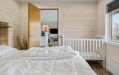 a bedroom with a crib and a mirror at Three-Bedroom Holiday Home In Vestervig in Vestervig