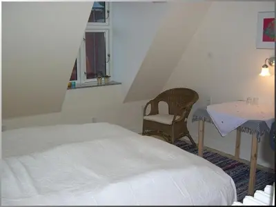 a bedroom with a bed and a table and a chair at Klosterpensionen in Viborg