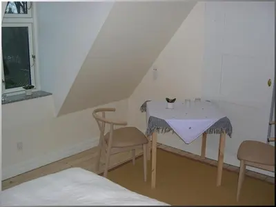 a room with a table with a cat sitting on it at Klosterpensionen in Viborg