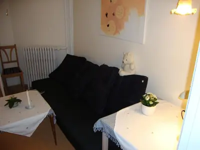 a living room with a black couch and a teddy bear at Klosterpensionen in Viborg