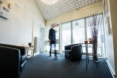 a person walking through a room with a table and chairs at Bed & Breakfast Holstebro in Holstebro