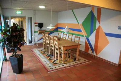 a dining room with a table and a colorful wall at Motel Spar 10 in Viborg