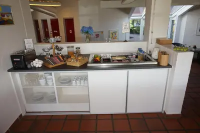 a kitchen with white cabinets and a counter at Motel Spar 10 in Viborg