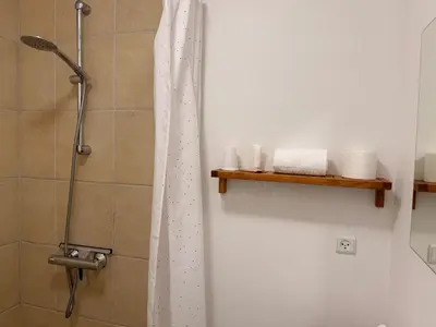a shower with a shower curtain in a bathroom at Guesthouse Hune in Blokhus