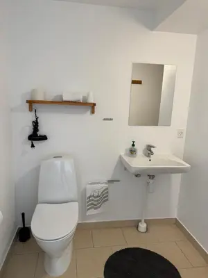 a bathroom with a white toilet and a sink at Guesthouse Hune in Blokhus