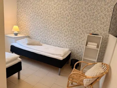 a small room with a bed and a chair at Guesthouse Hune in Blokhus