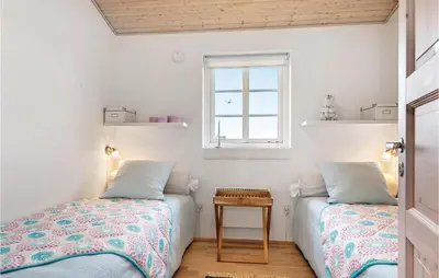 a bedroom with two beds and a window at Three-Bedroom Holiday Home In Harboore in Harboør