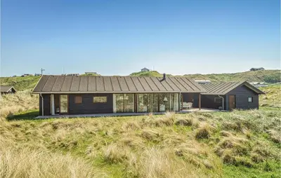 a house on top of a grassy hill at Five-Bedroom Holiday Home In Lokken in Løkken