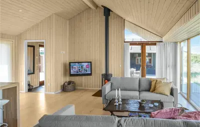 a living room with a couch and a table at Five-Bedroom Holiday Home In Lokken in Løkken