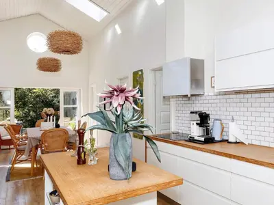a kitchen with a vase with a flower on a table at 6 person holiday home in Blokhus-By Traum in Blokhus