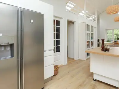 a kitchen with a stainless steel refrigerator and white cabinets at 6 person holiday home in Blokhus-By Traum in Blokhus