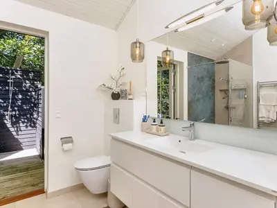 a bathroom with a sink and a toilet and a mirror at 6 person holiday home in Blokhus-By Traum in Blokhus