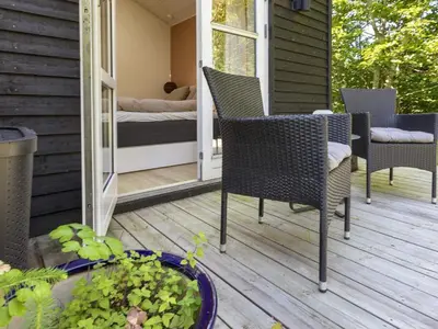 a porch with chairs and a bed on a house at 6 person holiday home in Blokhus-By Traum in Blokhus