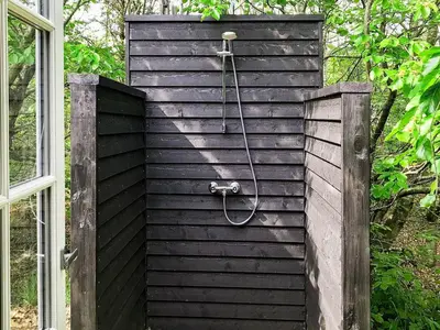 a shower in a black wall with a hose at 6 person holiday home in Blokhus-By Traum in Blokhus