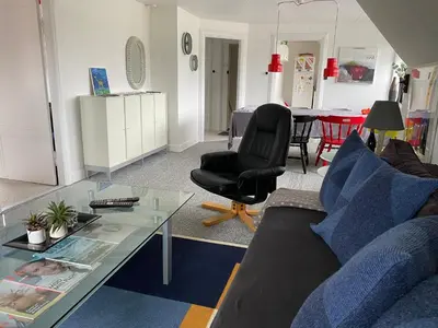 a living room with a couch and a glass table at Apartment med udsigt over Nordmors in Sejerslev