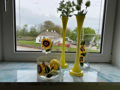 three vases sitting on a window sill with flowers in them at Apartment med udsigt over Nordmors in Sejerslev
