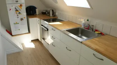 a small kitchen with a sink and a refrigerator at Apartment med udsigt over Nordmors in Sejerslev