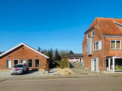a car parked in a parking lot next to a brick building at Apartment med udsigt over Nordmors in Sejerslev