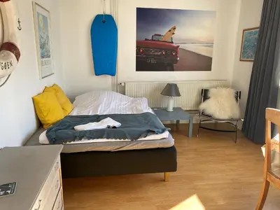 a small bedroom with a bed and a table at Motel Hune Apartments in Blokhus