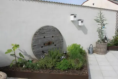 a garden with a wooden door in the side of a wall at Motel Hune Apartments in Blokhus