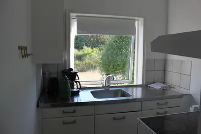 a kitchen with a sink and a window at Motel Hune Apartments in Blokhus