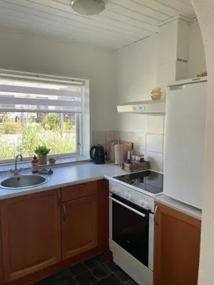 a kitchen with a sink and a stove top oven at Motel Hune Apartments in Blokhus