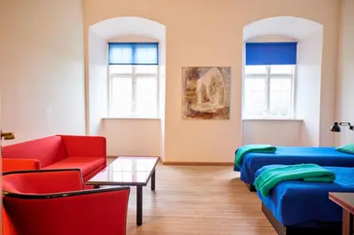 a room with two beds and a table and chairs at Vitskøl Kloster in Ranum