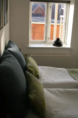 a bedroom with a bed with pillows and a window at Seaside Hotel Thyborøn in Thyborøn