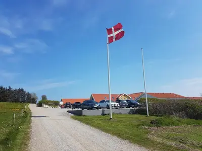 a flag on a pole on the side of a road at Hotel Højgaarden in Slettestrand