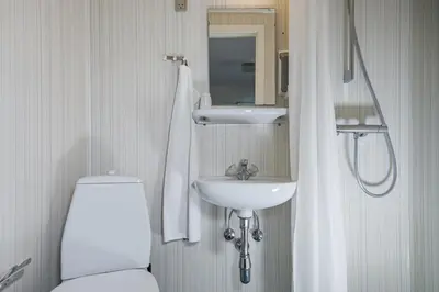 a bathroom with a toilet and a sink at Hotel Højgaarden in Slettestrand