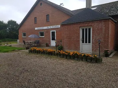 a brick building with a bunch of flowers in front of it at Kyndestoft Bed & Breakfast in Holstebro