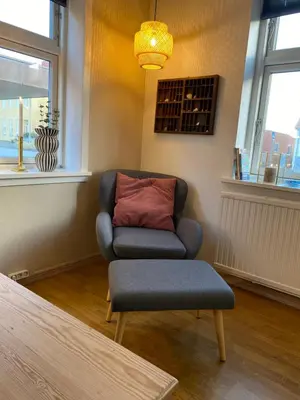 a living room with a chair and a pillow at Bredgade 10 Thyborøn in Thyborøn