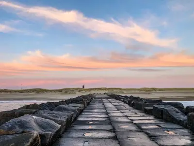 a stone pathway leading to the beach at sunset at Bredgade 10 Thyborøn in Thyborøn