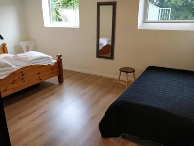 a bedroom with a bed and a table and a mirror at Bændal in Bækmarksbro