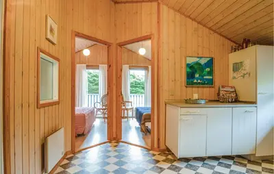 a kitchen with wooden walls and a refrigerator in a room at Four-Bedroom Holiday Home In Lokken in Løkken