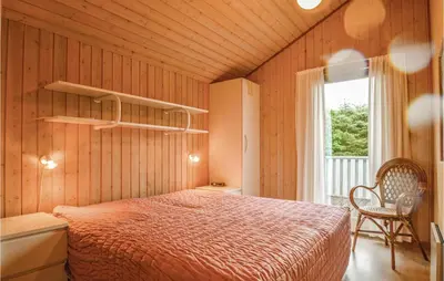 a bedroom with a bed in a room with a window at Four-Bedroom Holiday Home In Lokken in Løkken