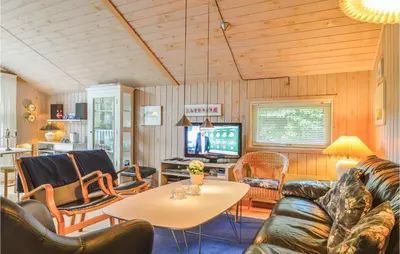 a living room with a couch and a table at Four-Bedroom Holiday Home In Lokken in Løkken