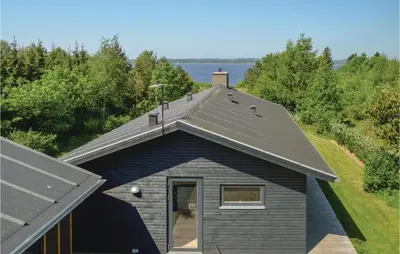 a house with a gambrel roof with a window at Three-Bedroom Holiday Home In Skals in Skals