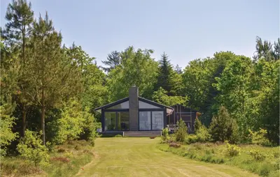 a house in the middle of a field with trees at Three-Bedroom Holiday Home In Skals in Skals