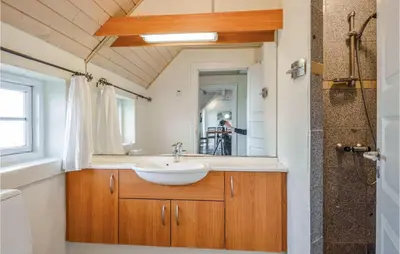 a bathroom with a sink and a mirror at Nice Home In Harboøre With Kitchen in Harboør