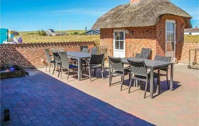 a table and chairs in front of a brick building at Nice Home In Harboøre With Kitchen in Harboør