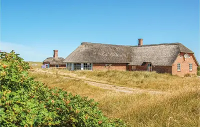 an old red brick house with a roof on a hill at Nice Home In Harboøre With Kitchen in Harboør