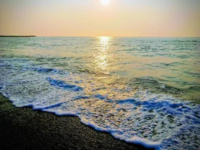 a beach with the sun rising over the ocean at 4 person holiday home in Thyborøn-By Traum in Thyborøn