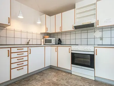 a kitchen with white cabinets and a microwave at 4 person holiday home in Thyborøn-By Traum in Thyborøn